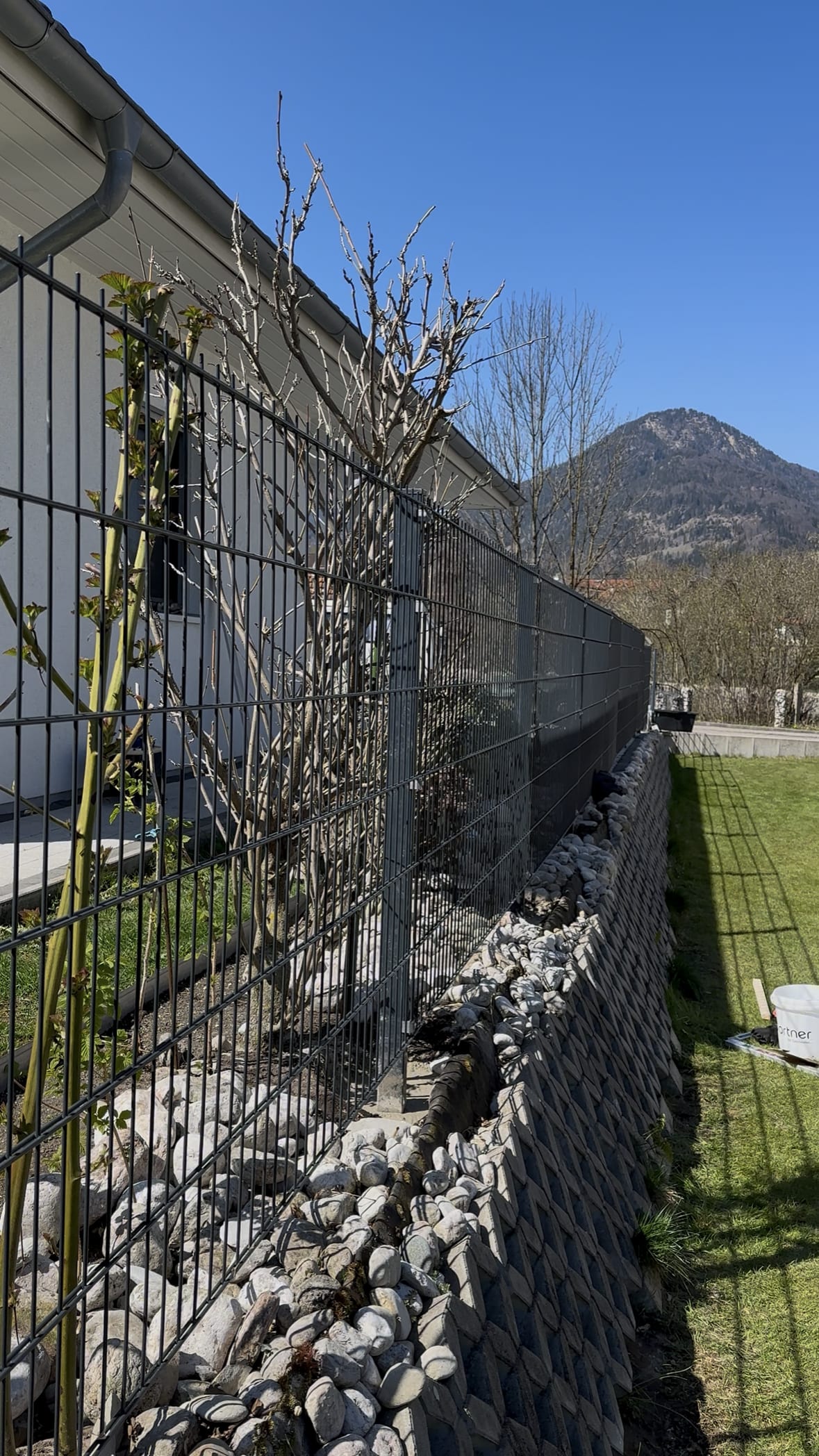 Neuer Doppelstabmattenzaun mit Steinsockel und Bergblick